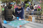 A New York City officer inspects gambling taking place in a Chinatown park